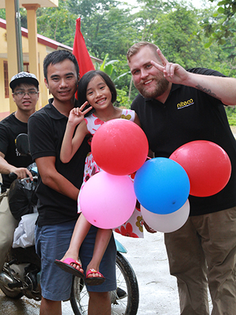 Happy children and adults celebrating with colorful balloons outdoors