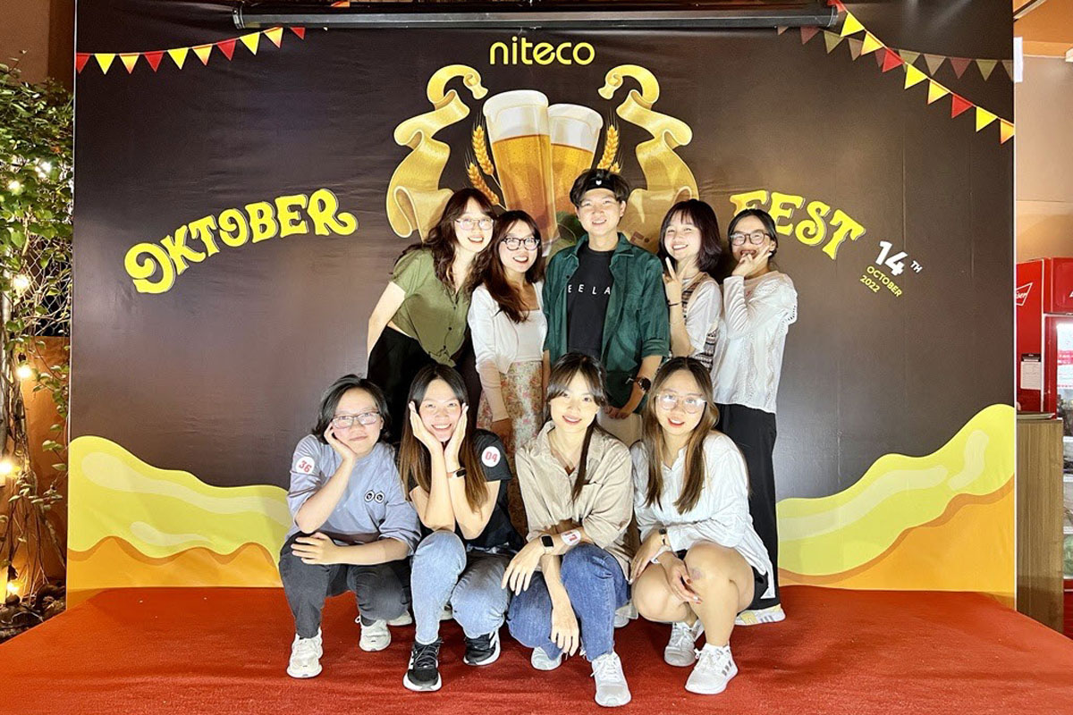 Niteco team celebrating Oktoberfest with festive backdrop and red carpet