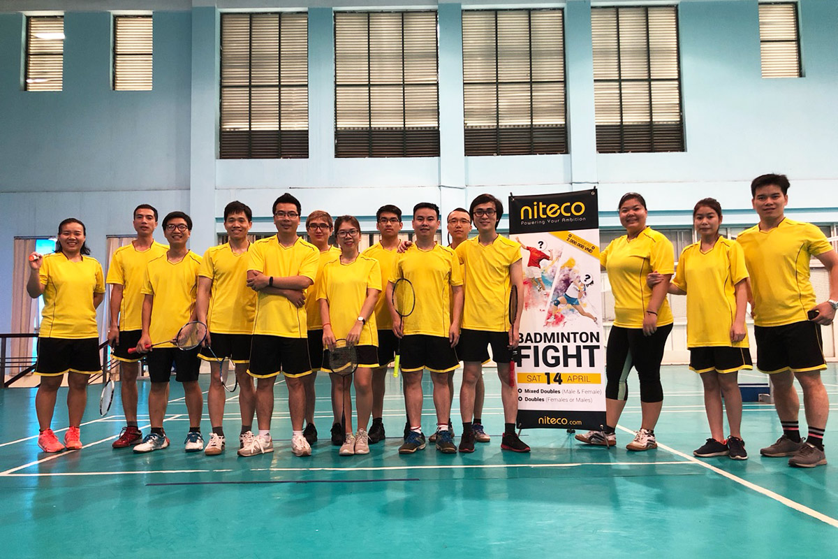 Team in yellow uniforms ready for badminton fight tournament at indoor court