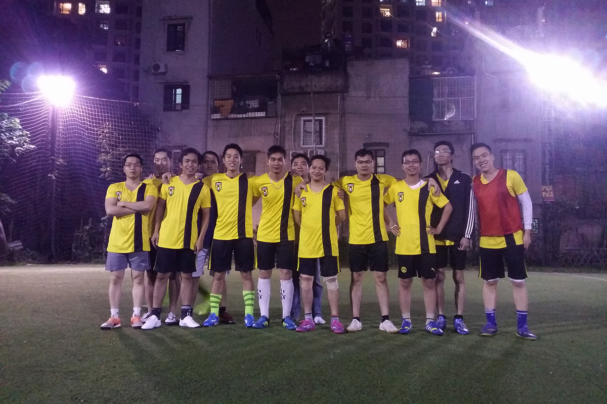 Soccer team in yellow jerseys lined up on the field at night under floodlights