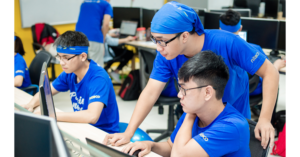 Young developers collaborating at computers in a Niteco software training session