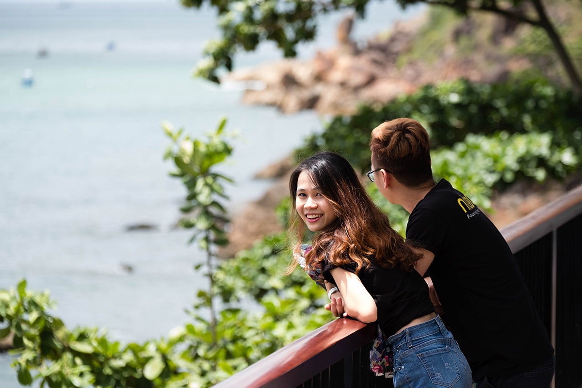Couple enjoying scenic ocean view and greenery on sunny day outdoors