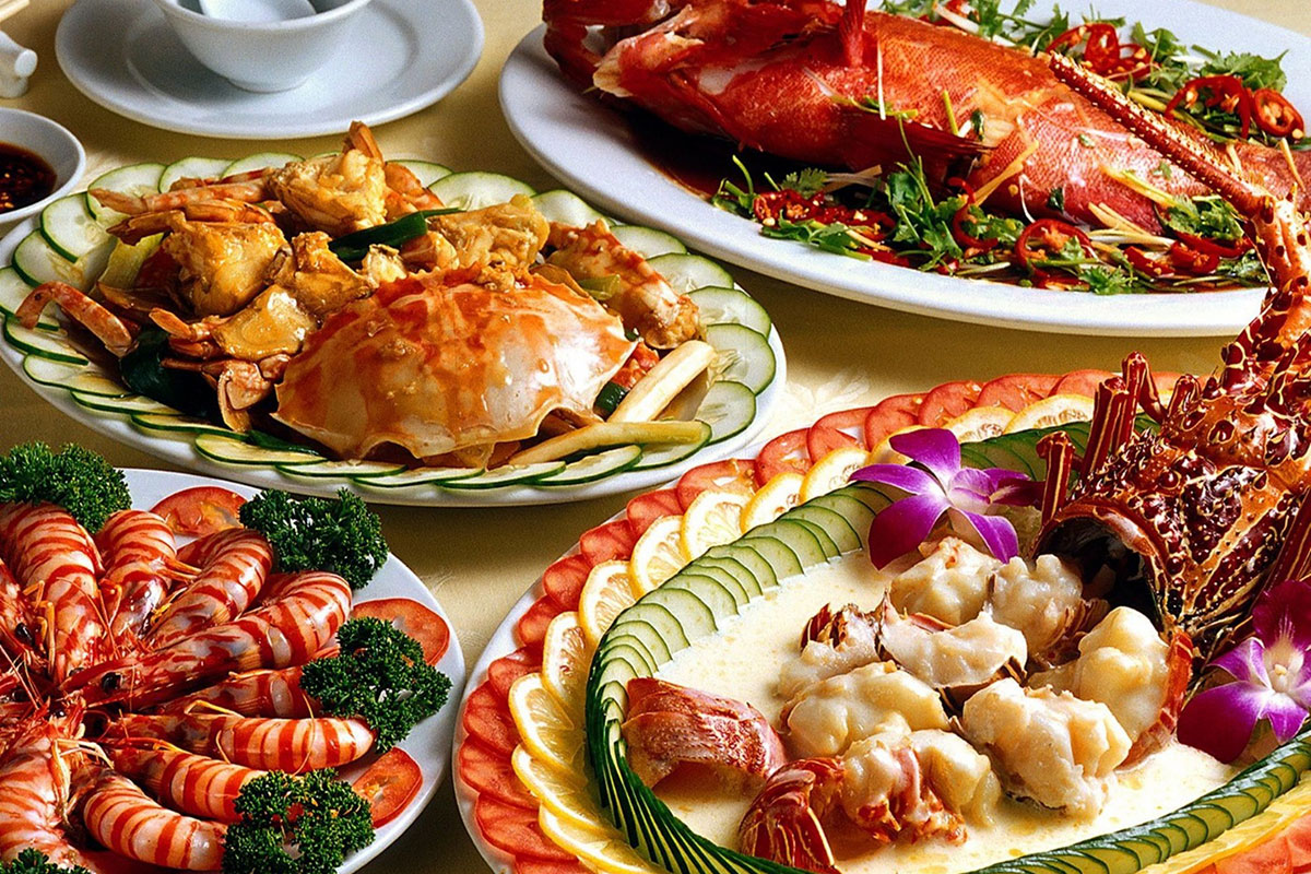 Seafood platter with lobster, shrimp, crab, and garnishes on a dining table