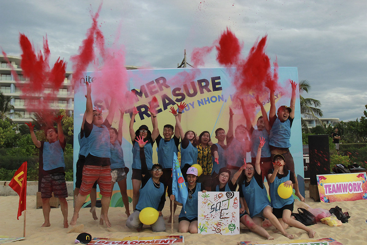 Teamwork with colorful powder celebration and beach activities at summer treasure event
