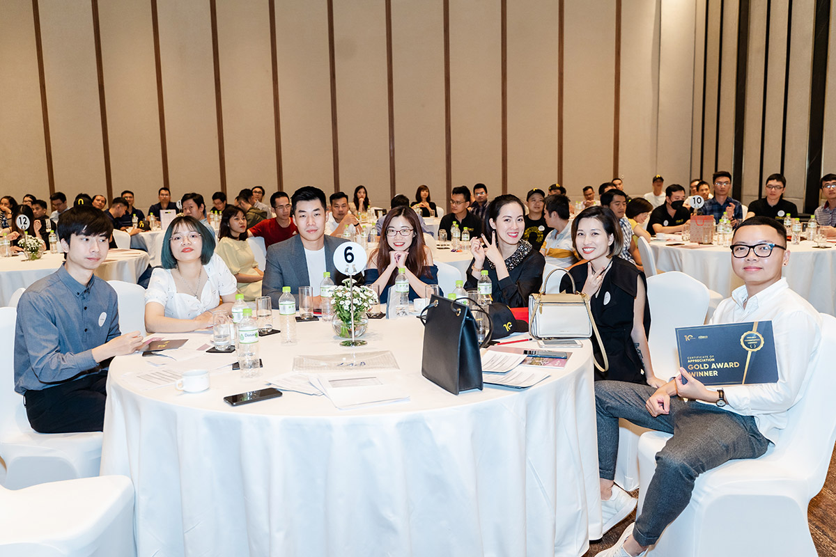 Group of young professionals at conference table with gold award certificate