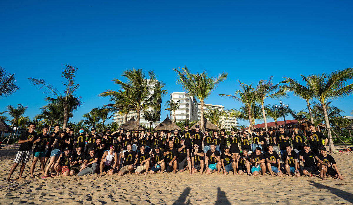 Team building event on sunny beach with palm trees and resort buildings