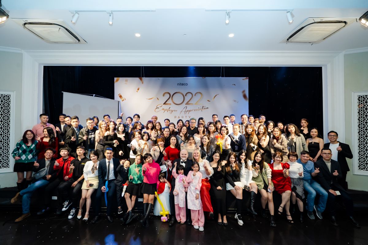 2022 Employee Appreciation Party group photo with smiling attendees and celebration decor