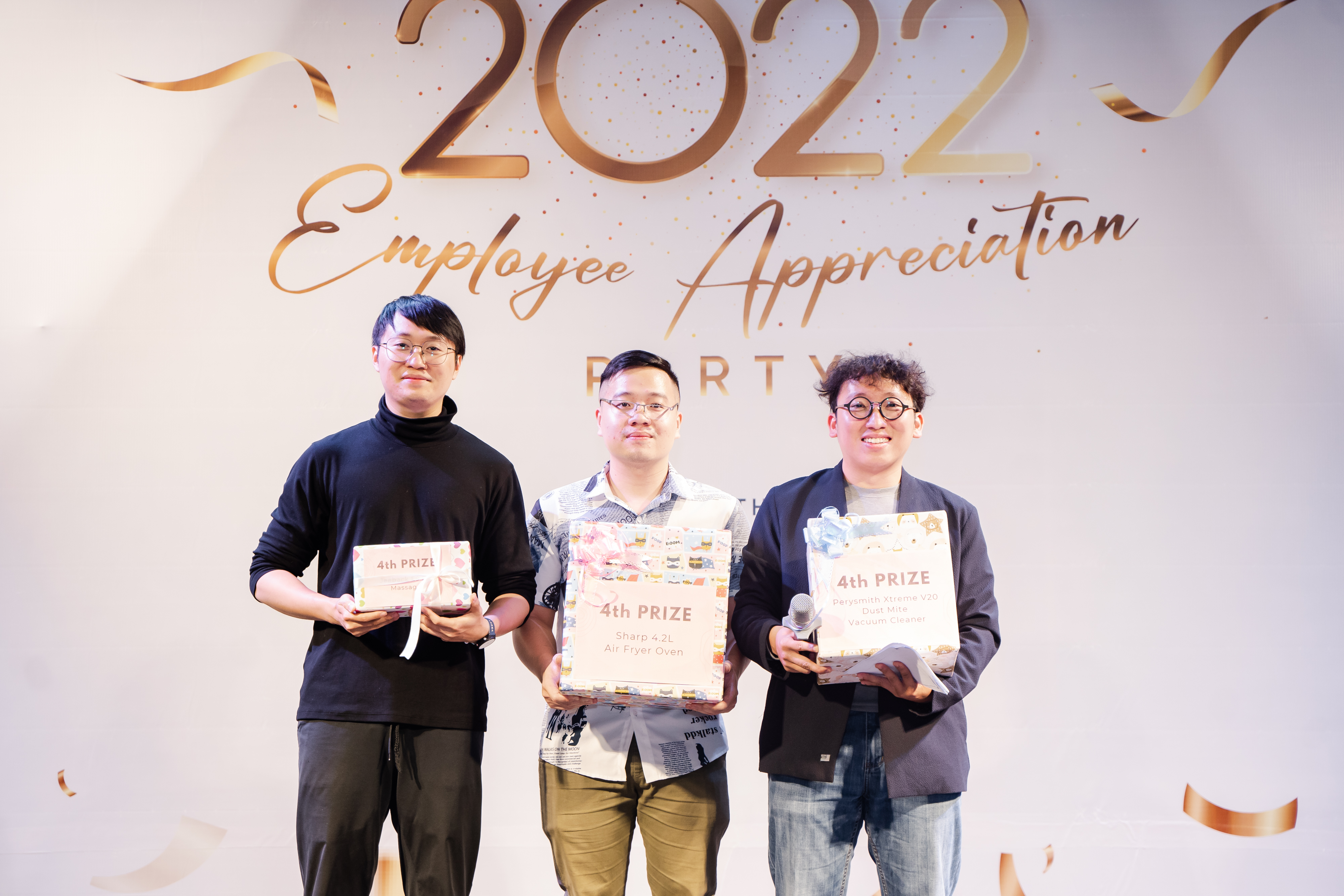 2022 Employee Appreciation Party winners holding 4th prize gifts on stage