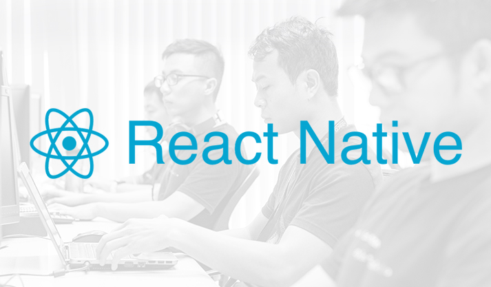 React Native developers collaborating on coding with laptops in office setting