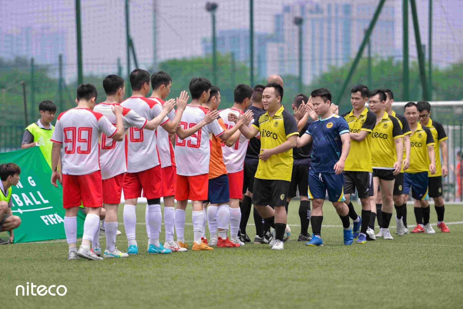 Soccer players from Niteco and opposing team shaking hands after match on field