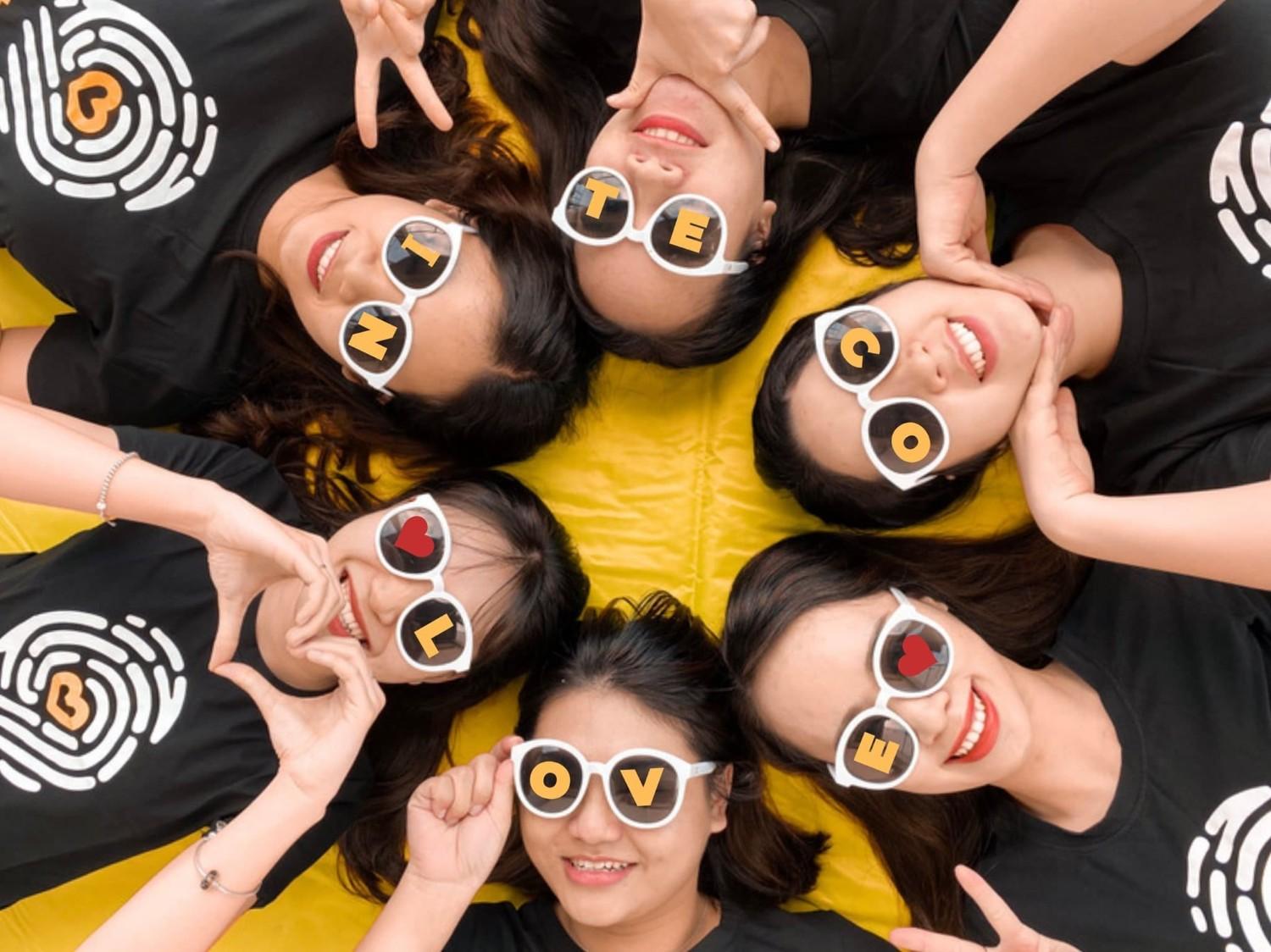 Women wearing sunglasses with letters spelling "Notice Love" and heart symbols