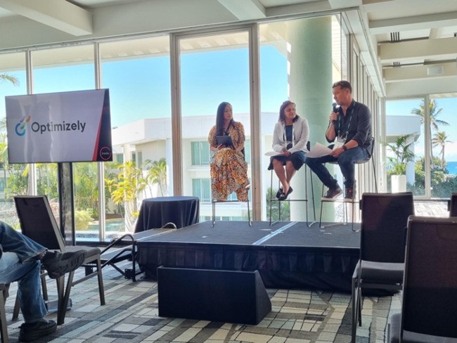 Optimizely panel discussion with three speakers in a modern conference room
