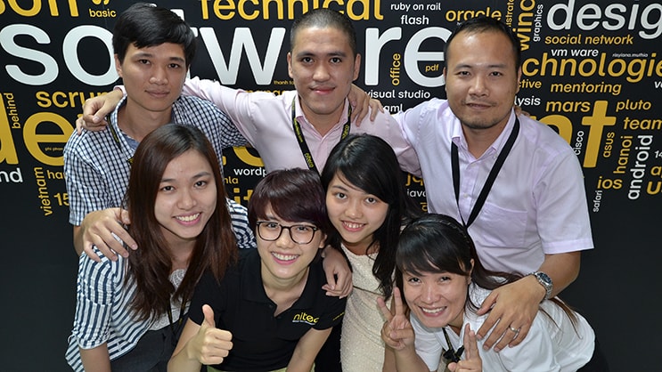 Group of software developers smiling and posing together in office environment