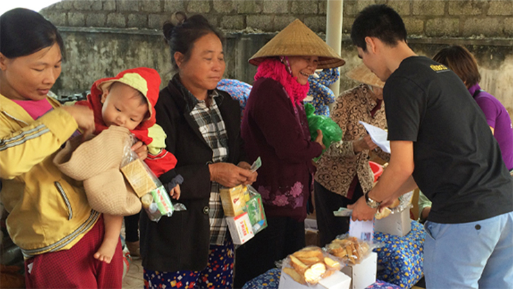 Community charity event with locals receiving food and supplies distribution