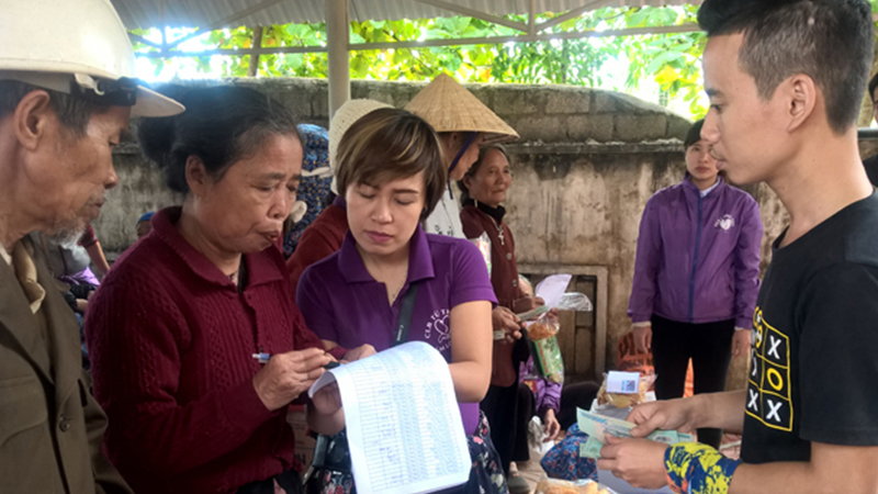 Community health workers assisting elderly with medical forms and medication guidance