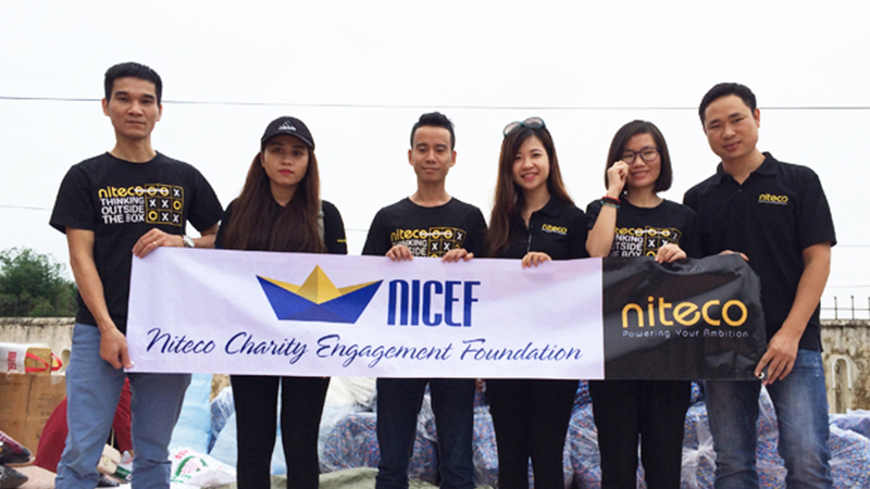 Niteco team holding NICEF banner for charity engagement event outdoors